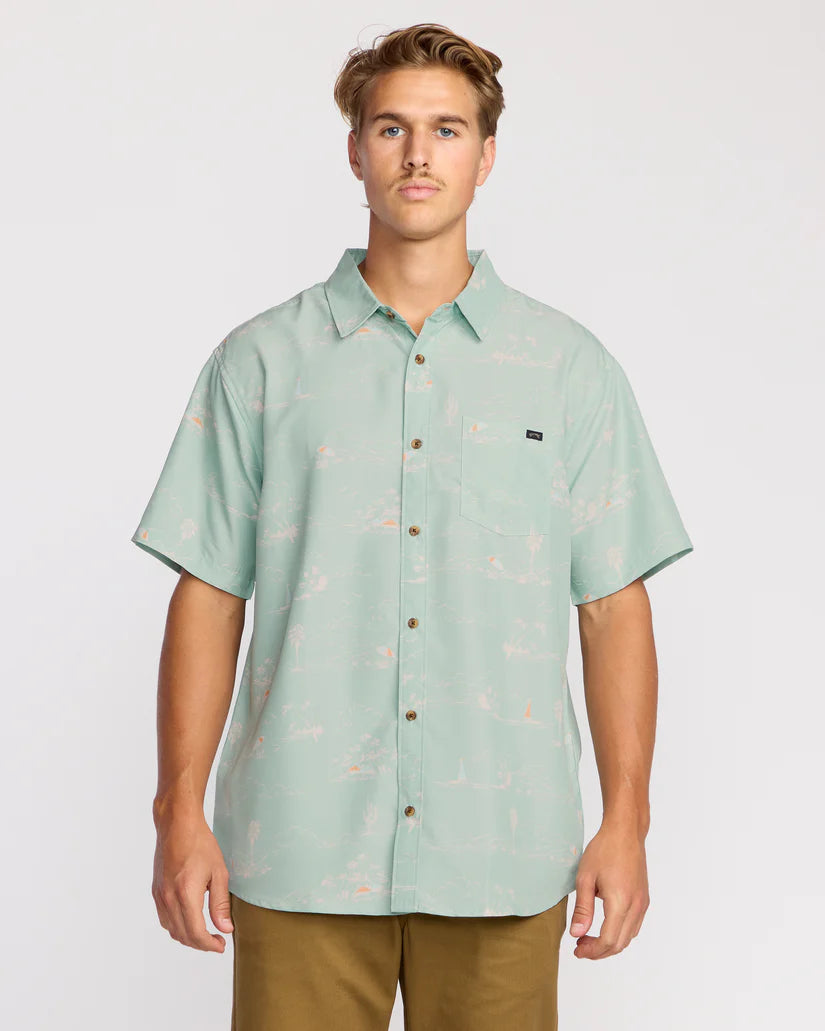 Man wearing a light green patterned shirt on a plain background