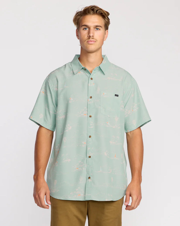 Man wearing a light green patterned shirt on a plain background