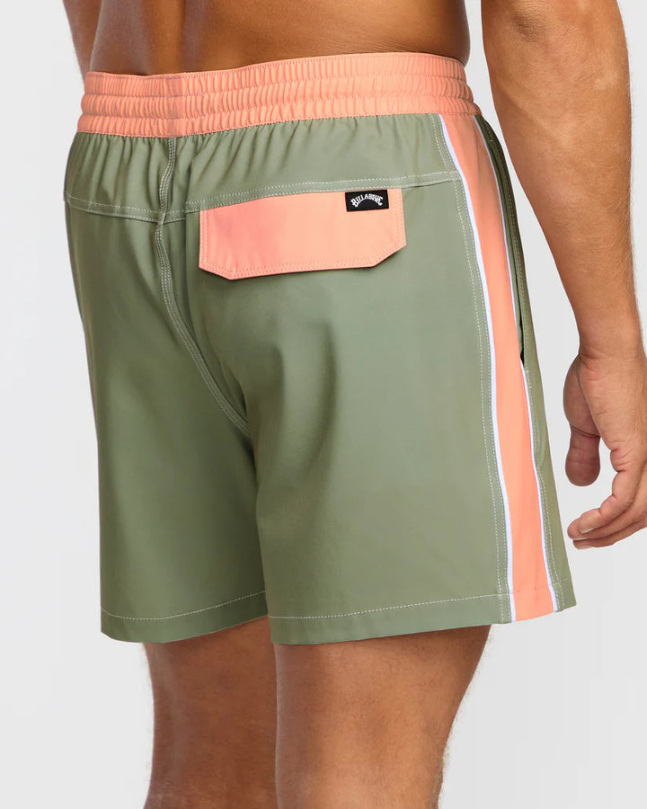 Green swim shorts with peach waistband and side stripe on a white background