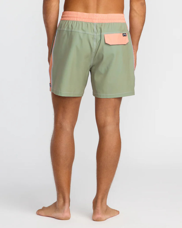 Person wearing green shorts with a pink waistband and pocket on a white background 1