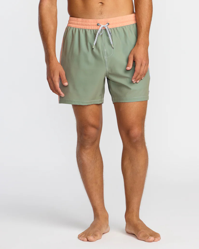 Person wearing green swim shorts with a peach waistband on a white background