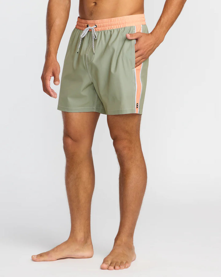 Person wearing green swim shorts with a pink waistband on a white 2background